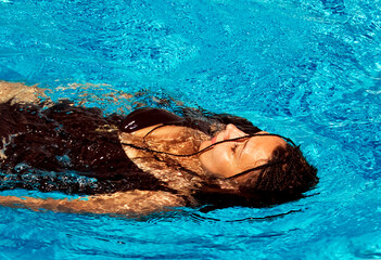 Young woman relaxing in swimming pool, summer vacationing, recreation and healthcare, peace of mind...