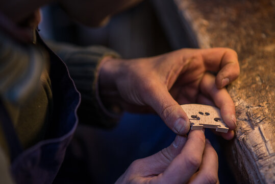Un Luthier cr&eacute;e un chevalet &agrave; l'aide d'un petit couteau il travaille le bois et lui donne la bonne  forme
A Luthier creates a bridge using a small knife he works the wood and gives it the right shape