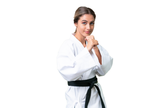Young Uruguayan woman over isolated background doing karate