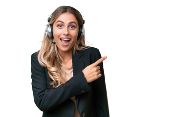 Telemarketer pretty Uruguayan woman working with a headset over isolated background surprised and pointing side - Powered by Adobe