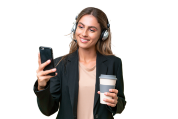 Telemarketer pretty Uruguayan woman working with a headset over isolated background holding coffee to take away and a mobile