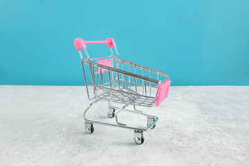 Empty metal grocery basket, on a blue background. The concept of online buying, selling, crisis in...