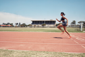 Woman, fast runner and sports on stadium track for marathon training or exercise wellness. Athlete person, motion blur and running workout or fitness cardio, energy and speed or race performance