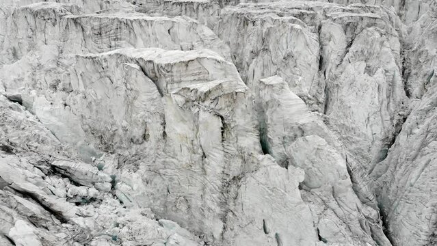 Spinning aerial flyover above the crevasses of the Moiry glacier near Grimentz in Valais, Switzerland on a cloudy summer day