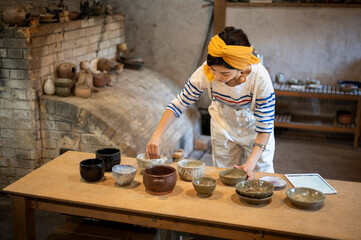 デジタルタブレットを使って商品管理をする陶芸家の女性