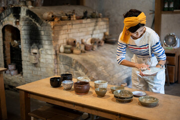 デジタルタブレットを使って商品管理をする陶芸家の女性