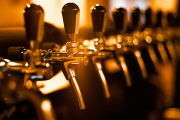 Creatively blurred image of faucets in beer pub with defocused bokeh and artistic digital noise....