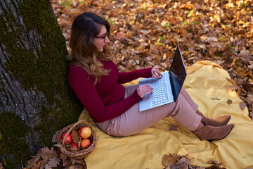 Businesswoman working on laptop in the forest