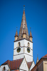 Fototapeta na wymiar Detailed view of the Sibiu Lutheran cathedral tower. Gothic architectural cathedral with colourful tiles.