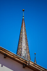 Lutheran cathedral tower in front of blue sky. Colourful tiles on a church tower. Sibiu old Lutheran cathedral tower.