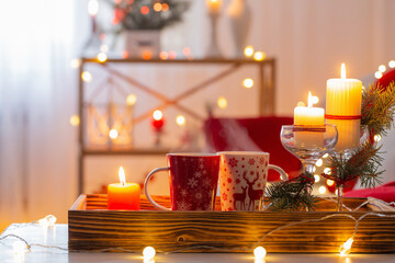 cup of hot drink with christmas decorations in white and red colors at home