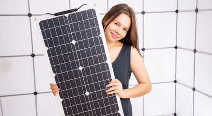 young woman in black dress holding a flexible solar panel