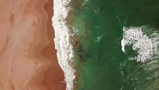 Aerial top view on ocean waves and sand beach on the Atlantic coast in Morocco