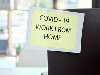 Covid, sign and work from home at the office for health and safety rules or regulations during pandemic. Label post of corona virus restrictions for working remote, quarantine or control at workplace