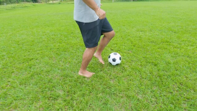 Running with a classic soccer ball on a green grass soccer field. close up on feet
