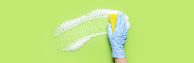 Hand of woman with sponge cleaning green surface - obrazy, fototapety, plakaty