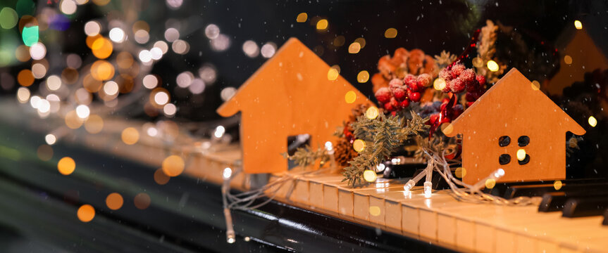 Beautiful Christmas decor and glowing lights on black piano, closeup