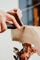 Profesional slicing Spanish jamon iberico (ham). Selective focus point