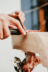Profesional slicing Spanish jamon iberico (ham). Selective focus point