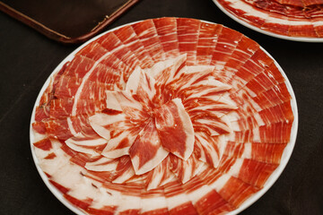 Plate with Iberian cut ham. Spanish jamon iberico (ham). Selective focus point