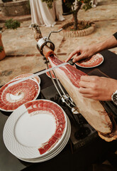 Profesional slicing Spanish jamon iberico (ham). Selective focus point