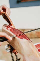 Profesional slicing Spanish jamon iberico (ham). Selective focus point