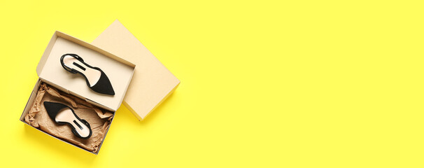 Cardboard boxes with woman's shoes on yellow background with space for text