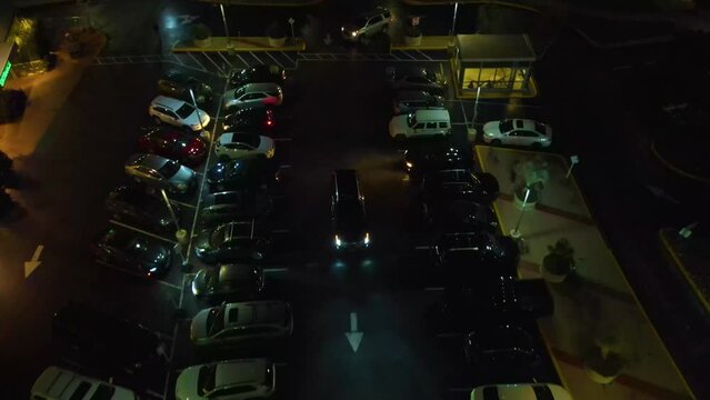 Austin Texas at night. A car pulls into the parking lot slowly looking for a spot to park. The cinematic feel of the video is great for a short film.