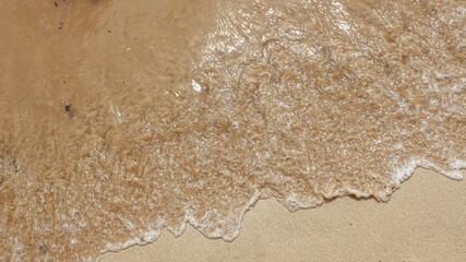 Splashing waves on the beach with beautiful sand. Vacation to the beach in summer. Children's play area.