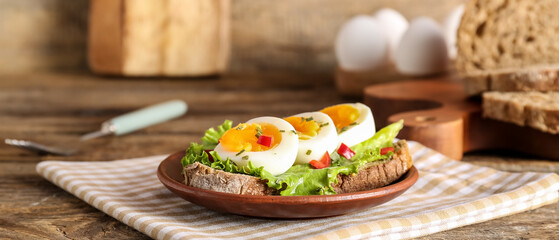 Plate with delicious toast on wooden table