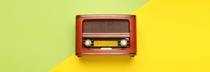 Retro radio receiver on color background, top view