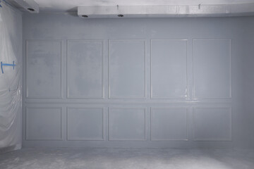 Grey fresh painted wall with frames in room