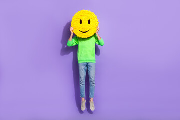 Full length photo of funky funny guy dressed neon sweatshirt jumping high smiling pinata cover close face isolated violet color background
