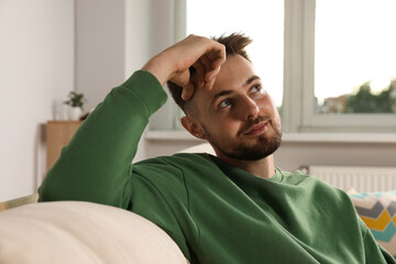 Portrait of handsome man on sofa at home