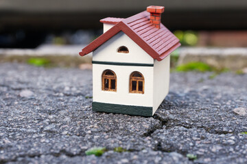 Obraz na płótnie Canvas House model on cracked asphalt. Earthquake disaster