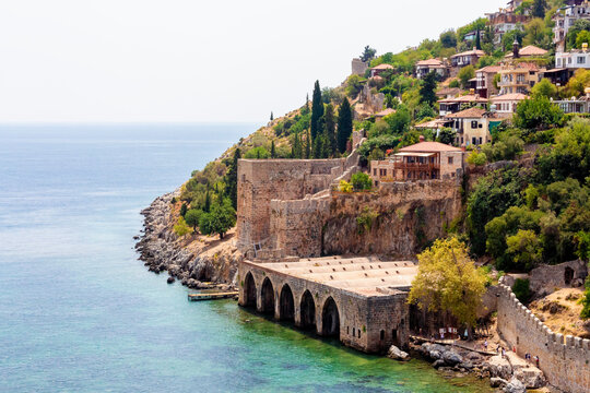 Ancient shipyard (Tersane) near of Kizil Kule tower in Alanya, Turkey (Turkiye) Famous tourist destination with high mountains. Part of medieval fortress (Alanya Castle) on the mountainside
