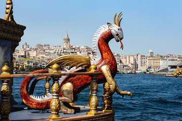 View of Galata Tower and Golden Horn with a dragon-prowed boat in the foreground. Selected focus, close-up. Istanbul, Turkey - obrazy, fototapety, plakaty