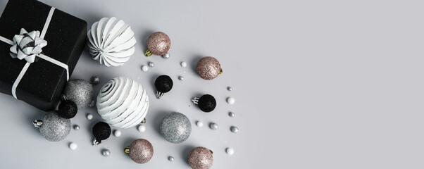 Composition with Christmas gift and beautiful balls on light background with space for text