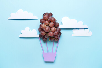 Composition with air balloon made of grape in blue sky