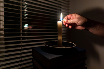 Blackout. Woman lighting a candle with a match