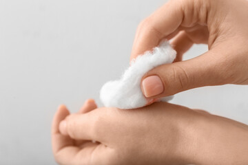 Naklejka premium Woman with cotton wool on light background, closeup