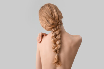 Blonde woman with pigtail hairstyle on light background