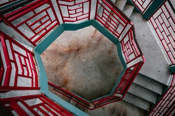 Top view of an outdoor spiral staircase with beautiful decorative red railings © Andrew Hoyle/Wirestock Creators