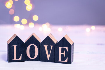 Decorative word love on a blurred background with bokeh lights.