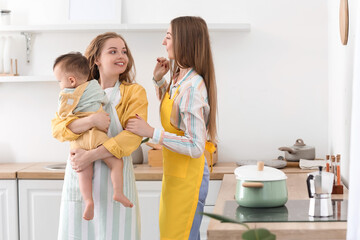 Lesbian couple with their little baby in kitchen