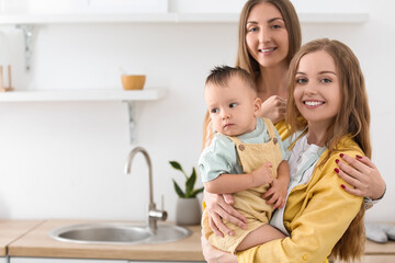 Lesbian couple with their little baby in kitchen