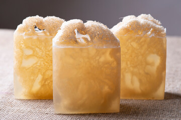 Soap with loofah sponge inside. Glycerin soaps with natural scrub. - obrazy, fototapety, plakaty