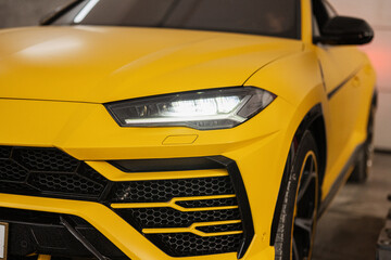 Fototapeta premium Headlights of yellow sport car suv.