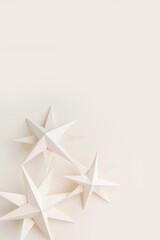 Merry Christmas.Christmas stars handmade light beige background.Monochrome,Christmas background,holiday card.DIY christmas flat lay copy space.Christmas zero waste, paper, eco postcard