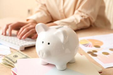 Obraz na płótnie Canvas Piggy bank with notebooks on table, closeup. Budget concept